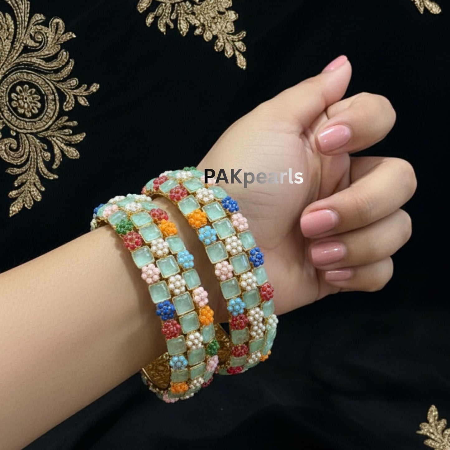 Macro detail showing square-cut translucent pink stones alternating with blue, orange, and mint seed pearl flower