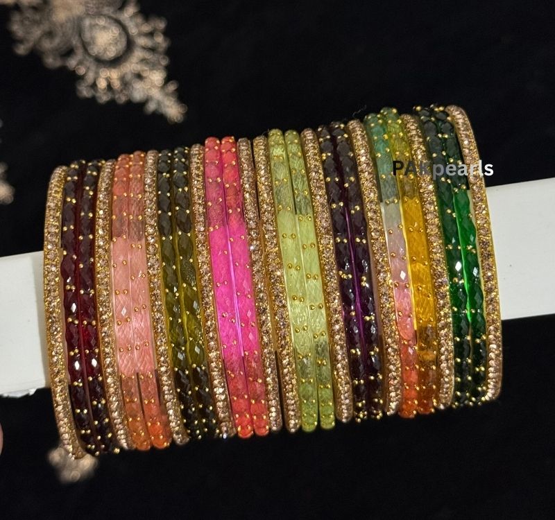Vibrant assortment of Pakistani and Indian glass bangles in pastel and jewel tones, highlighting the shimmering raindrop texture.